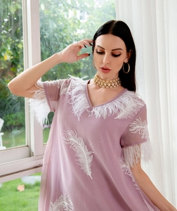 Close-up of lavender chiffon dress featuring V-neckline and delicate white feather trim