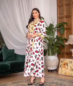 Detail of floral kaftan dress featuring gold embroidery, sequins, and red rose patterns