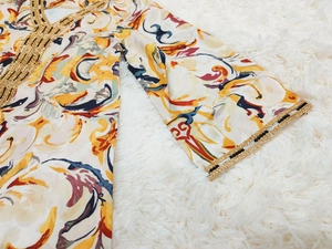 Détail de l'abaya ethnique avec broderie dorée complexe et motifs imprimés colorés