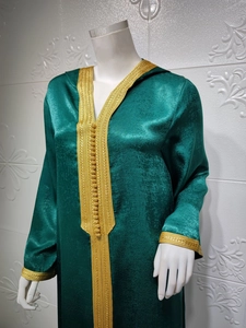 Detailed golden embroidery and traditional buttons on green satin kaftan dress