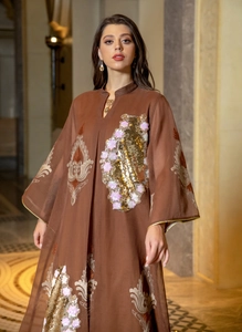 Detailansicht eines braunen Abendkleids mit goldenen und rosa Pailletten