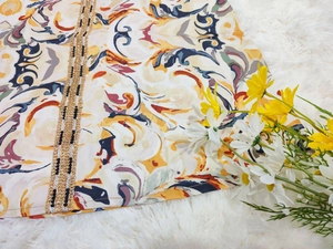 Détail d'une abaya à motif paisley avec garniture de chaîne dorée et ruban rayé chic