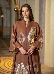 Detailansicht eines eleganten braunen Abendkleids mit Pailletten und feiner Blumenstickerei