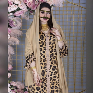Detailed view of leopard print dress with lace trim and gold Middle Eastern accessories