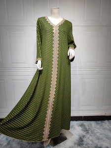 Detailaufnahmen der Stickerei und Goldpunkte auf dem olivgrünen Maxikleid mit langen Ärmeln