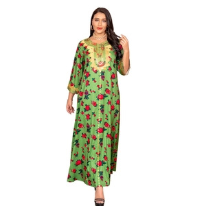 Detail of green long sleeve kaftan dress with golden embroidery and red floral patterns