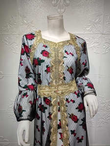 Detail of floral printed mesh dress with intricate gold lace embroidery on black kaftan