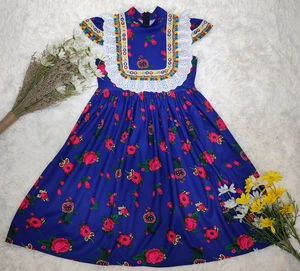 Detailed view of floral embroidery and white lace on this navy blue girl's summer dress