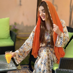 Détail du caftan imprimé avec écharpe orange et bordure perlée de style bohème chic