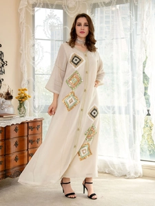 Close-up of beige kaftan dress featuring intricate sequined diamond embroidery patterns