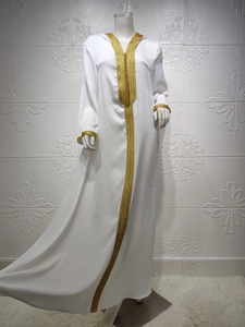 Detailed embroidery on white long-sleeve caftan with gold lace trim on velvet fabric