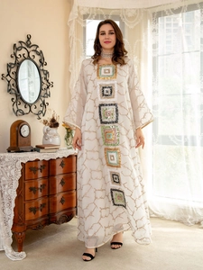 Close-up of sparkling sequin embroidery on cream long sleeve kaftan dress fabric