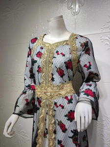 Detail of golden lace trim and floral embroidery on a white mesh ethnic dress
