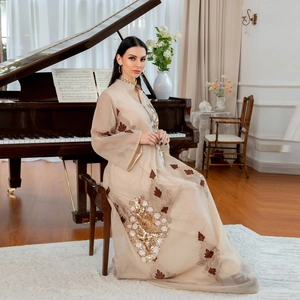 Elegantes beiges Abendkleid mit goldenen Paillettenstickereien, getragen von einem Model