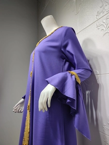 Detail of purple dress with golden embroidered lace trim and layered ruffle sleeves