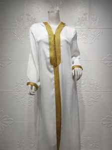 Exquisite gold braided trim and traditional buttons on a luxury white kaftan dress