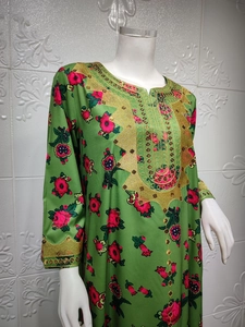 Detail view of emerald green kaftan with floral prints and intricate gold embroidery