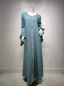 Detail of teal Muslim abaya featuring silver embroidery, pearls, and ruffled lotus sleeves