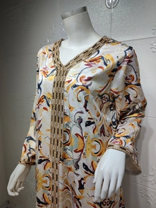 Gros plan détaillé sur les bordures dorées d'une robe abaya kaftan avec motifs ethniques