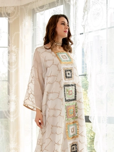 Close-up of beige long sleeve dress with colorful sequin geometric embroidery details