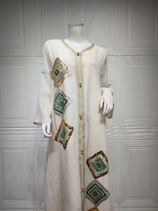 Détail de broderie de paillettes multicolores sur robe caftan beige et dentelle