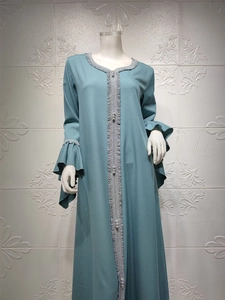 Detail of abaya neckline featuring silver pleated trim and decorative beaded buttons
