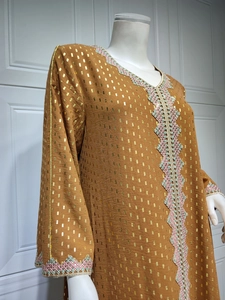 Detailansicht der Goldfolienmuster und bunten Stickerei am braunen Kaftan-Kleid