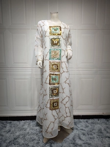 Detail of square sequin embroidery on white long sleeve maxi dress with gold branch patterns