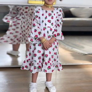 Robe bébé fille à fleurs avec manches à volants et roses roses sur tissu blanc