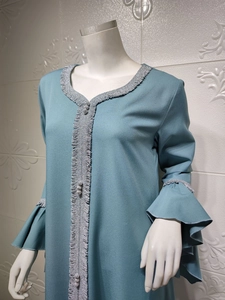 Detail of grey-blue lotus sleeve dress with ruffled edges and silver embroidery