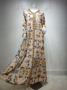 Détail du col en V avec broderie dorée sur un caftan en satin à imprimé floral