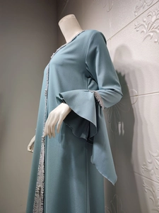 Detail of grey-blue abaya showing lotus leaf flare sleeves with silver sequin tassel trim