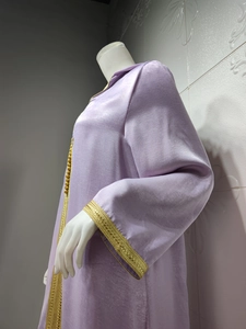 Detailed view of champagne velvet dress with golden embroidery on sleeves and neckline