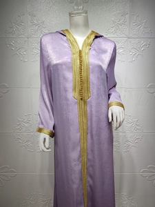 Detailed close-up of golden embroidery and beadwork on the purple silk kaftan hood
