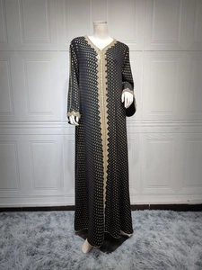 Detail einer schwarzen Abaya mit Goldfolienpunkten und bunten Stickereien am Kragen