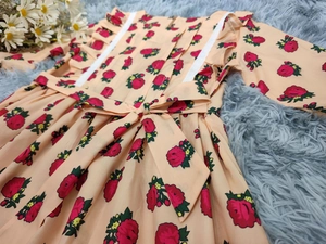 Détail d'une robe fleurie pour fille avec bordure en dentelle blanche et nœud à la taille