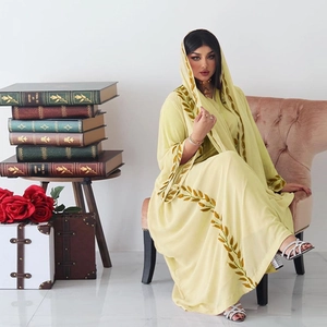 Detail of elegant light yellow abaya with golden embroidery and matching hijab scarf