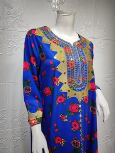 Detail of royal blue caftan with red floral prints and gold embroidery on neckline