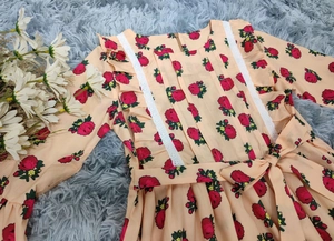 Détails de robe fleurie pour fille avec imprimés de roses rouges et dentelle blanche