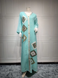 Détail de la robe caftan bleu clair avec bordure dorée et broderie de paillettes