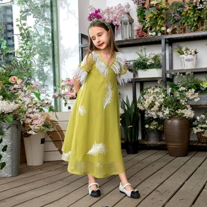 Detail of avocado green girl's V-neck dress with white feather embroidery and mesh fabric