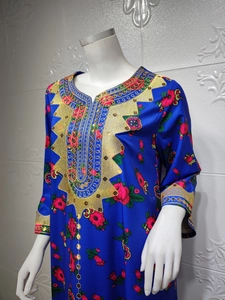 Detail of blue silk dress featuring golden embroidery and red rose floral prints