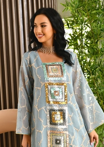 Close-up of light blue ethnic tulle dress with detailed geometric sequin embroidery