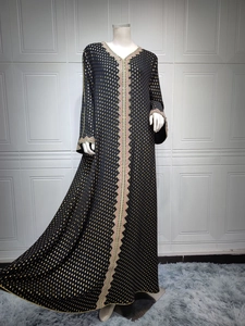 Detail eines schwarzen Abaya-Kleides mit goldener Metallpunkt-Stickerei und Wellenspitze