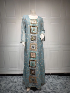 Detail of light blue kaftan dress with colorful sequin embroidery and gold patterns