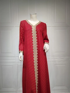 Nahaufnahme der goldenen Textur und Stickerei am roten Kaftan-Maxikleid
