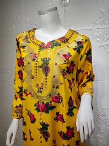 Close-up of golden embroidery and sequins on the yellow floral long sleeve dress