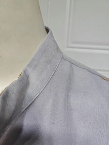 Detailansicht eines lila Abendkleides mit Fokus auf Kragennaht und Stoffstruktur