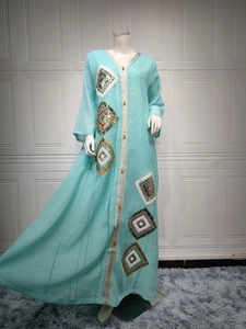 Détail d'une robe caftan bleu clair avec broderies de diamants et sequins brillants