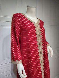 Detail der Stickerei auf rotem Kaftan mit Goldmuster und bunter Spitzenverzierung